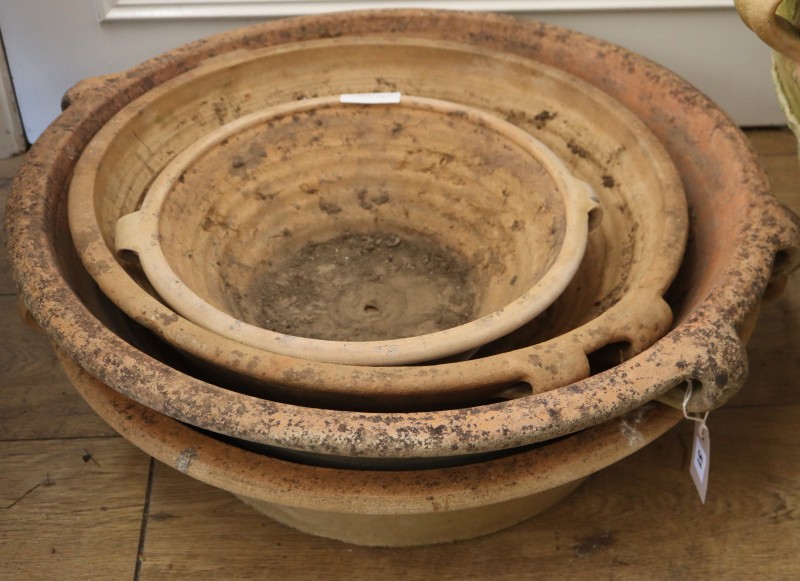 Four circular terracotta garden dishes, largest diameter 60cm